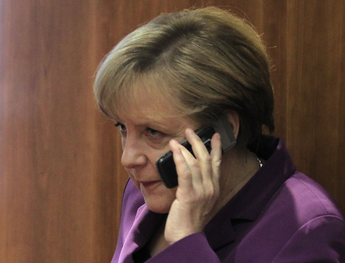 File photo of Germany's Chancellor Merkel using her mobile phone before a meeting at a European Union summit in Brussels